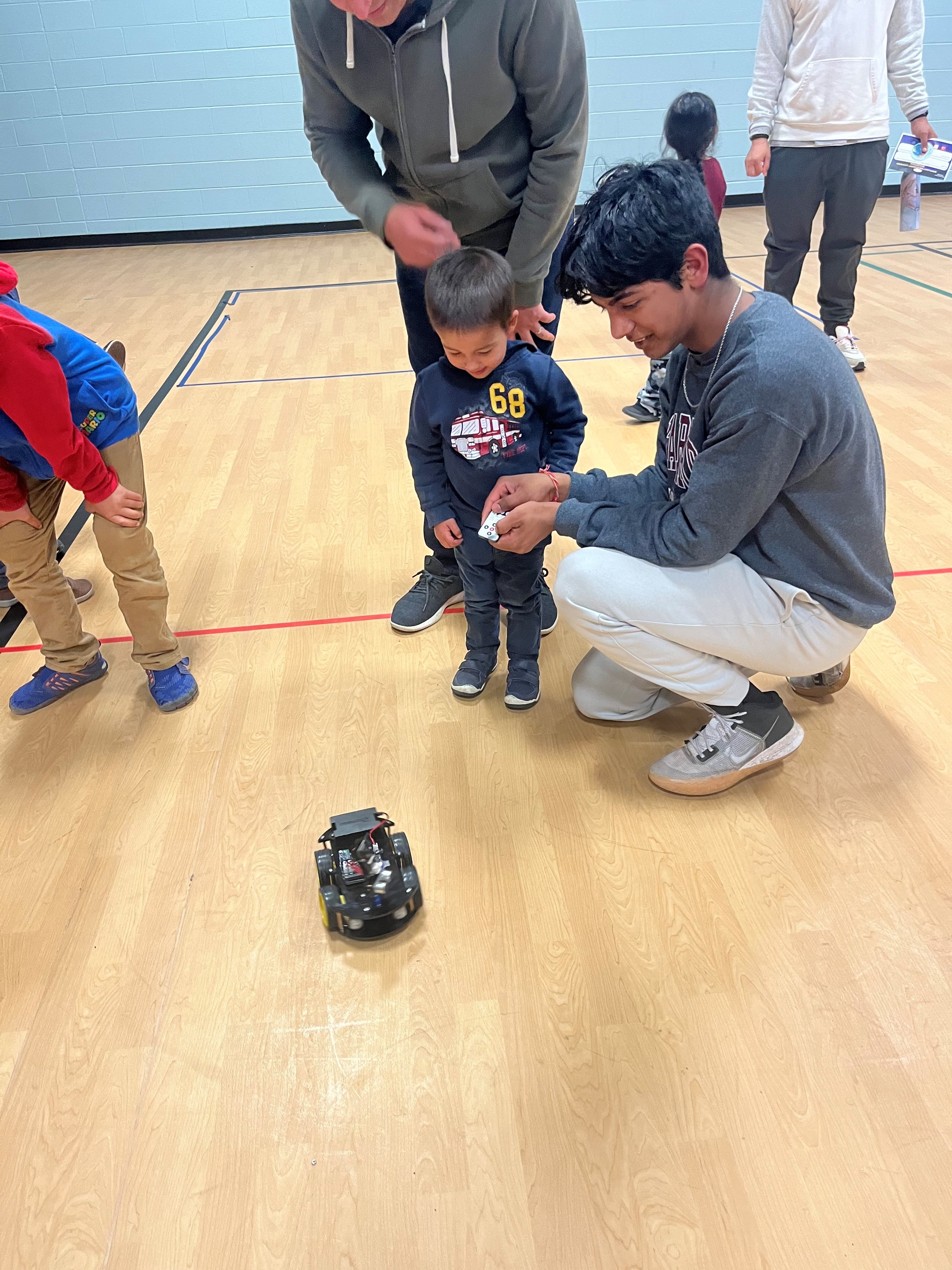 CHS student supporting child with using robot