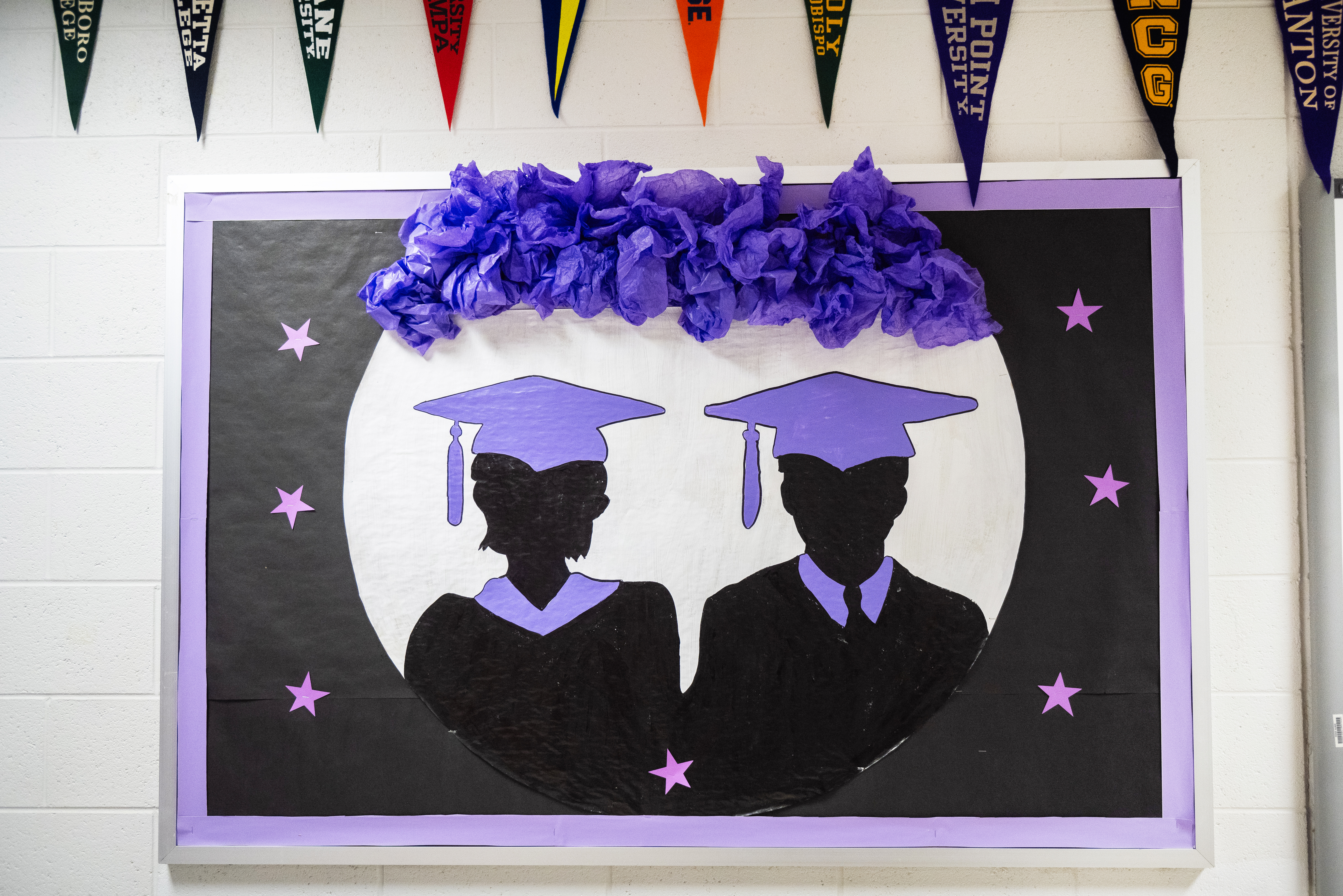 Image of wall inside career center with shadow images of students graduating