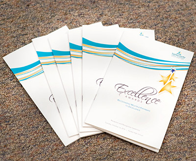 a photo of programs for the excellence ceremony